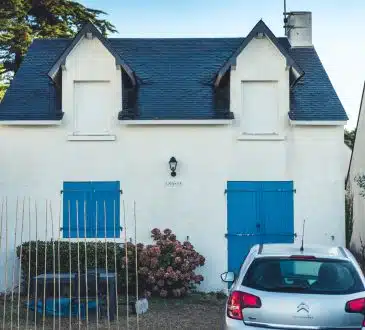 blue and white concrete house with blue metal gate