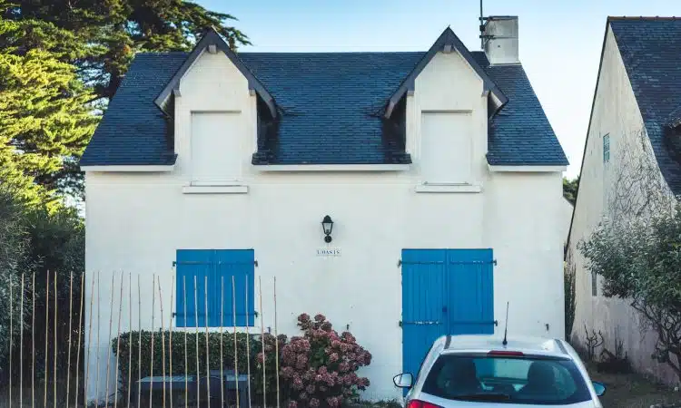 blue and white concrete house with blue metal gate