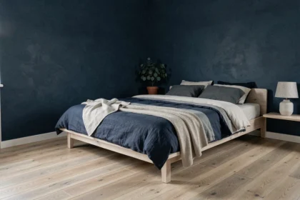 Chambre scandinave aux murs bleu nuit mat avec literie en lin superposée et parquet chêne clair, décoration minimaliste 2026