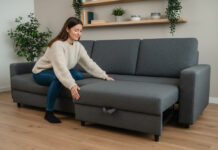Réinventer son intérieur avec un canapé convertible pour petit espace Jeune femme déployant un canapé convertible dans un intérieur minimaliste