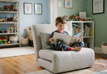 Les avantages du fauteuil convertible 1 place dans une chambre d’enfant Garçon de 7 ans lisant un livre dans sa chambre chaleureuse
