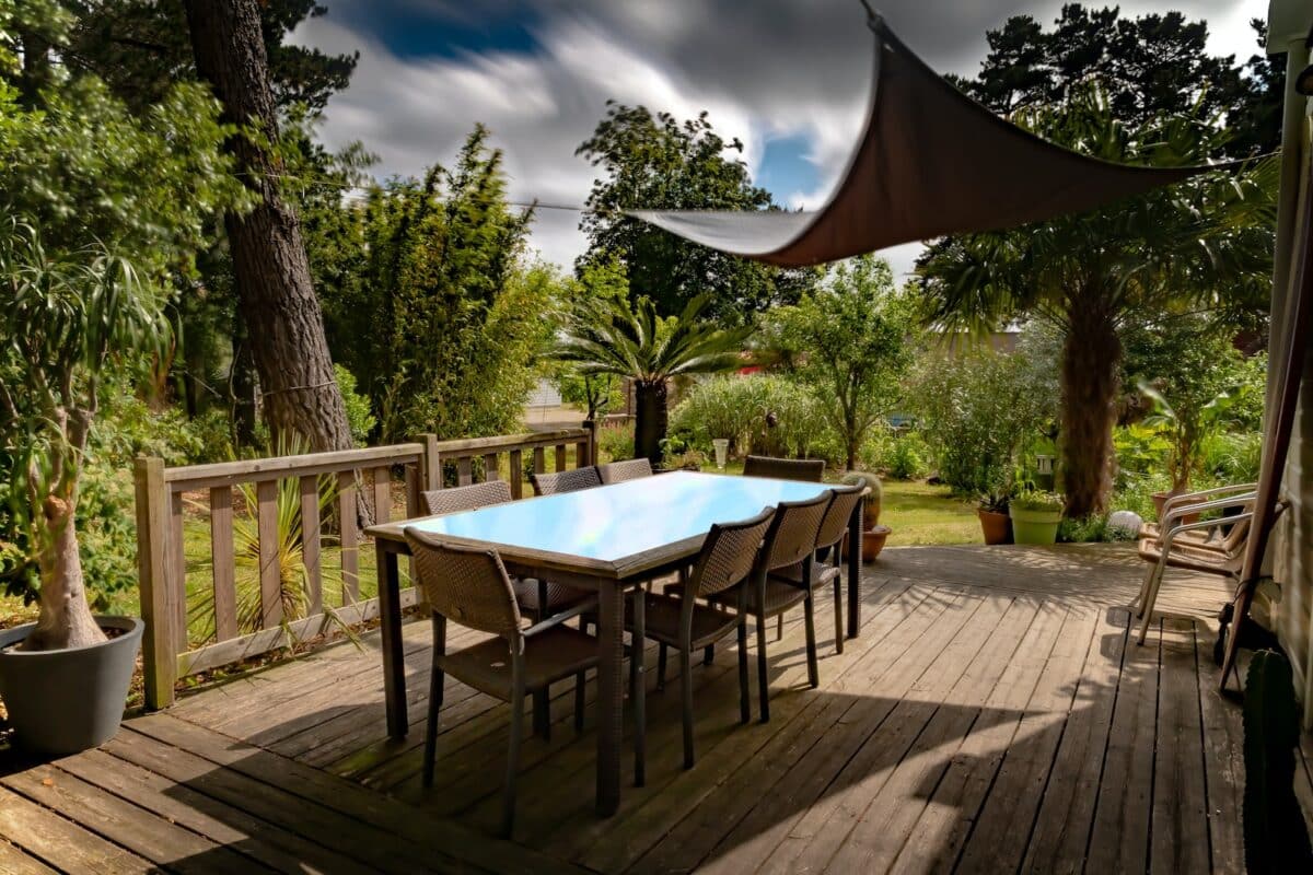 brown wooden table with chairs and umbrella