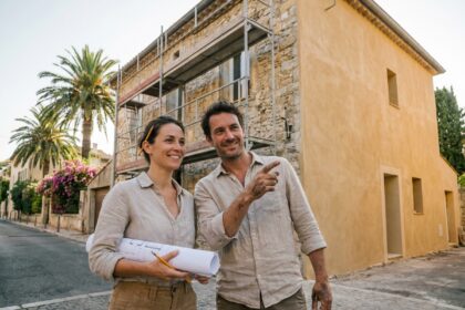Couple devant une maison provençale en cours de rénovation à Cannes avec des plans architecturaux